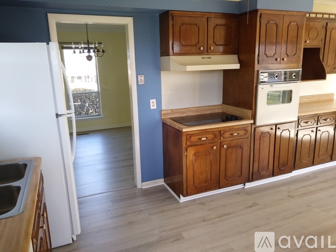 A kitchen with wooden cabinets and a white refrigerator.