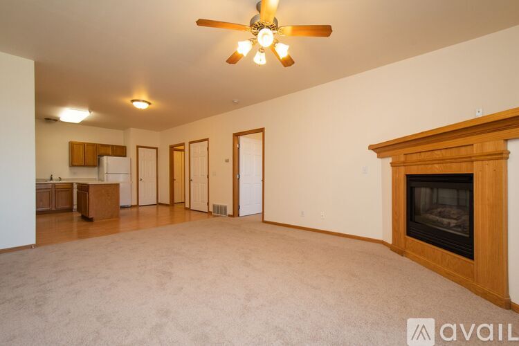 A living room with a fireplace and a ceiling fan.