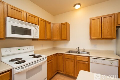A kitchen with wooden cabinets and white appliances.