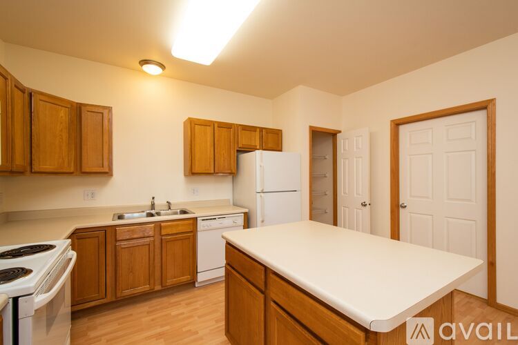 A kitchen with wooden cabinets and a white fridge.