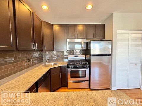 A kitchen with brown cabinets and stainless steel appliances.