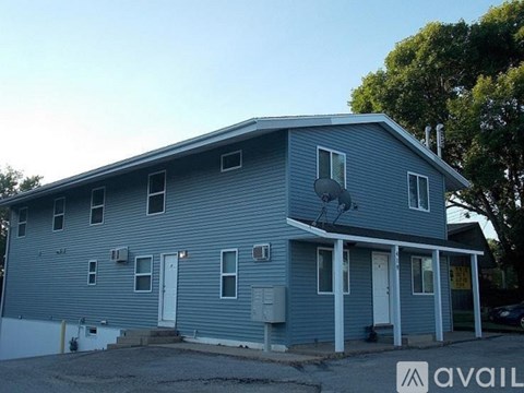 A blue house with a white door and windows.