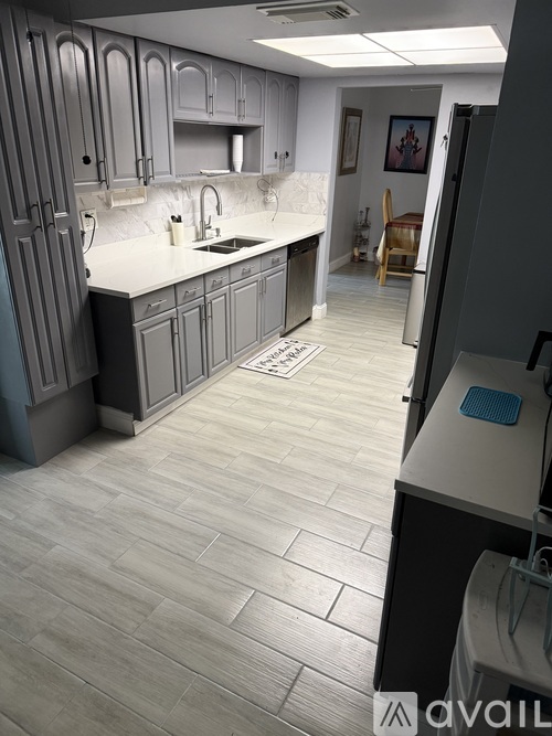 A kitchen with a sink, a dish rack, and a window.