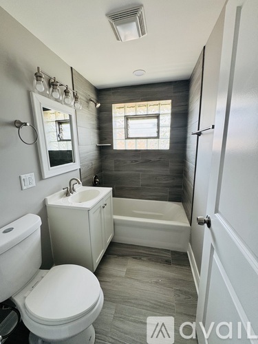 A bathroom with a toilet, sink, and tub.