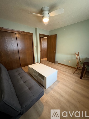 A living room with a grey sofa and a white coffee table.