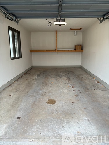 A spacious garage with a concrete floor and a window on the left wall.