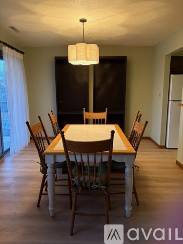 A dining room with a table and chairs.