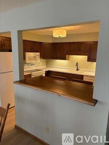 A kitchen with wooden cabinets and a white refrigerator.