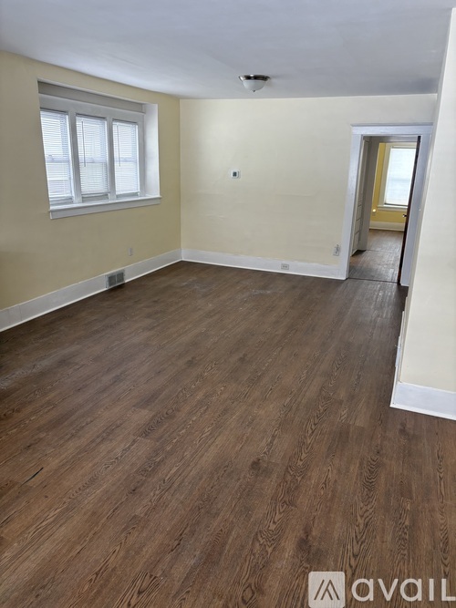 A room with wooden flooring and a window.