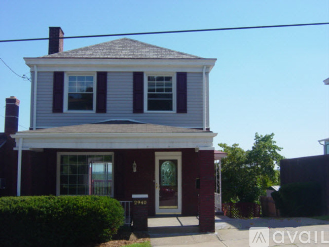 A two-story house with a red door and white trim.