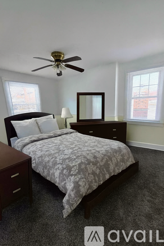 A bedroom with a bed, dresser, and mirror.