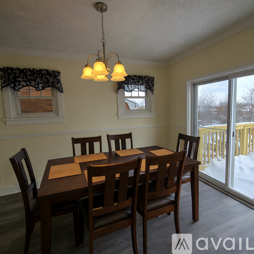 A dining room with a table and chairs.