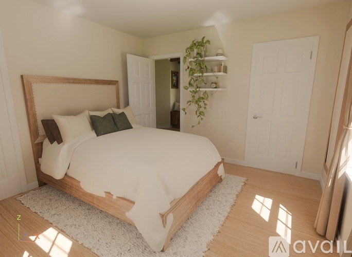 A bedroom with a large bed and a window letting in sunlight.