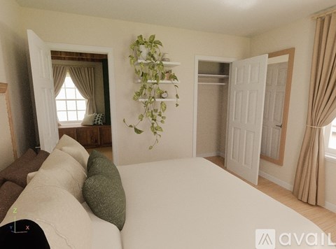 A living room with a white couch and a green plant on the wall.