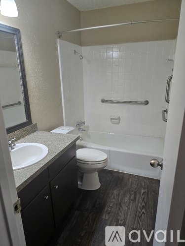A bathroom with a toilet, sink, and shower.