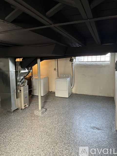 A room with a floor covered in tiles and a white wall with a window.