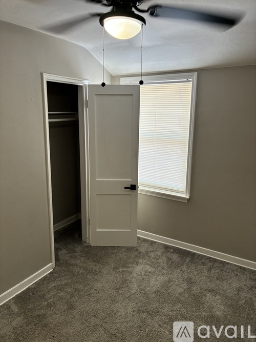 A room with a ceiling fan and a door.