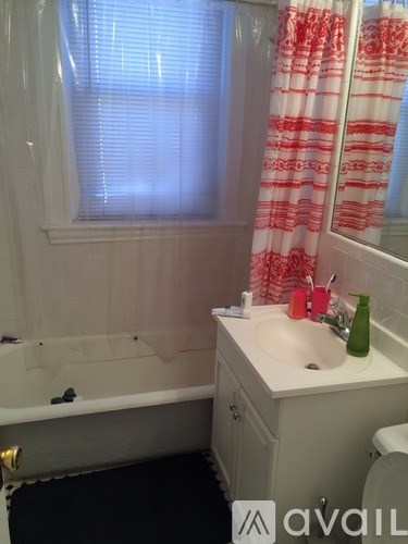 A bathroom with a white sink and a bathtub.
