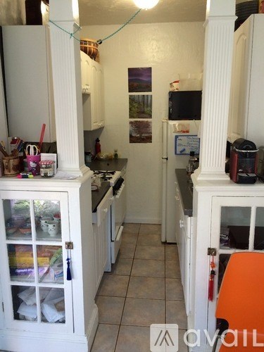 A kitchen with white cabinets and a tiled floor.