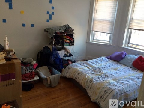A bedroom with a bed, a dresser, and a window.