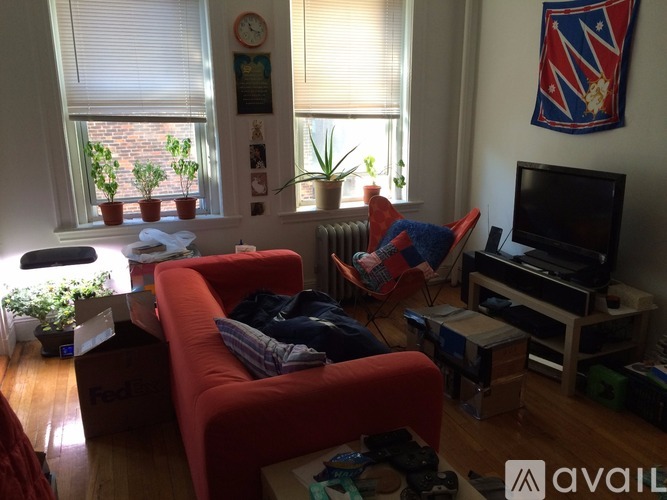 A living room with a red couch and a television.