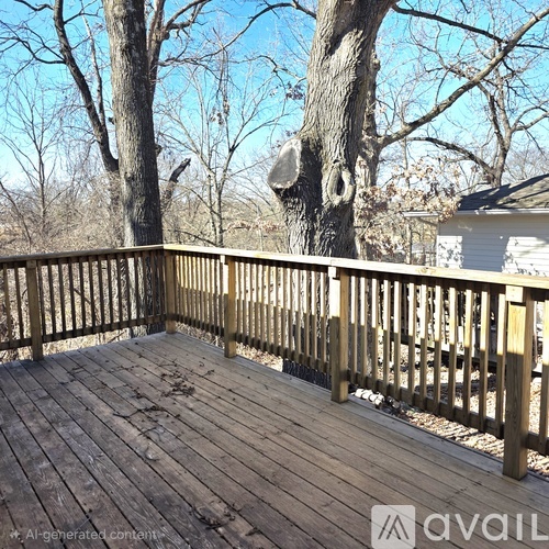 A wooden deck with a railing and trees in the background.