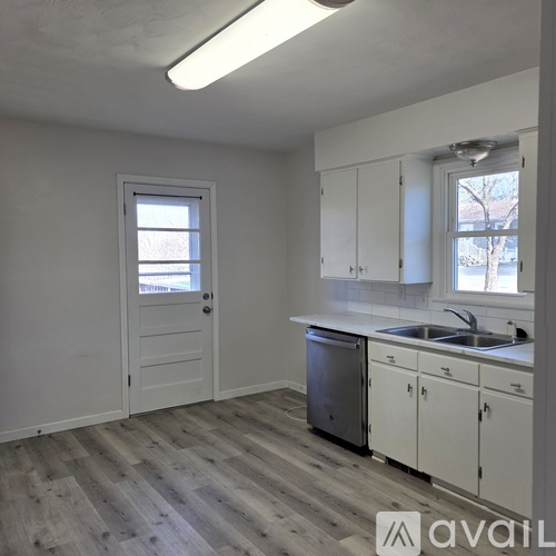 A kitchen with white cabinets and a dishwasher.