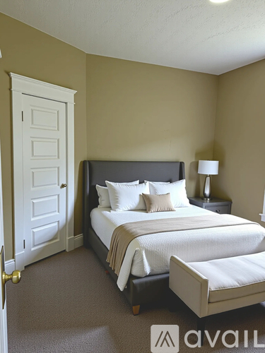 A bedroom with a large bed and a white door.