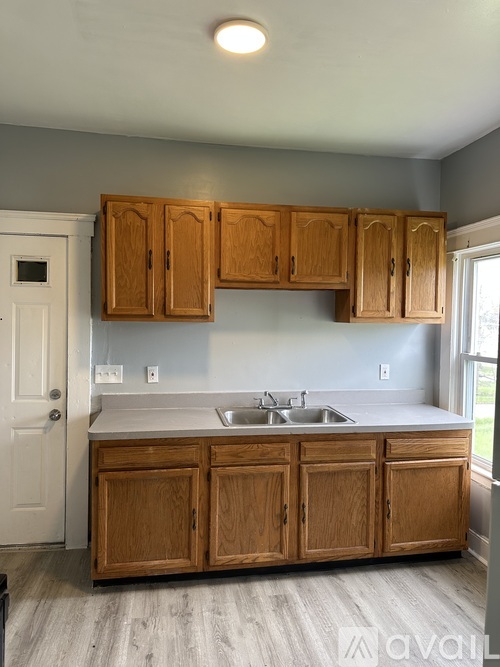 A kitchen with wooden cabinets and a white sink.