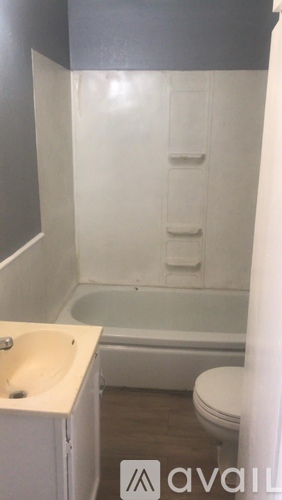A bathroom with a toilet, sink, and bathtub.