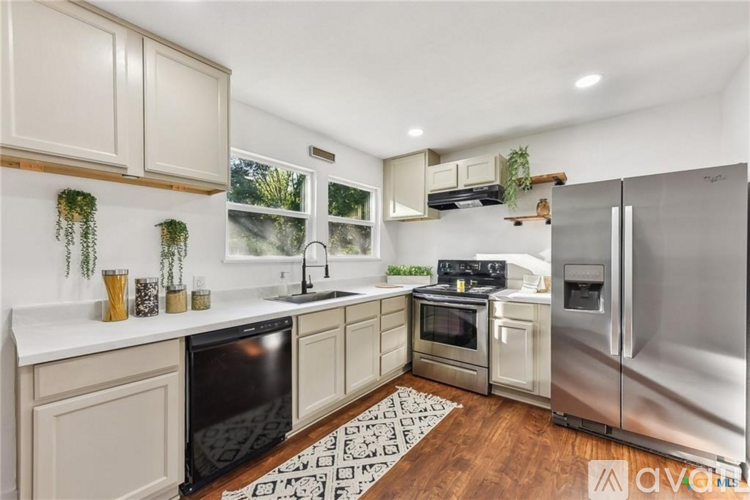 A kitchen with a black oven and a stainless steel refrigerator.