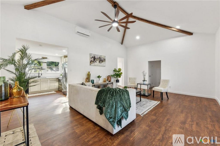 A living room with a white couch and a green throw blanket.