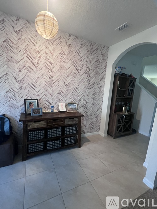 A room with a chevron wallpaper and a wooden shelf.