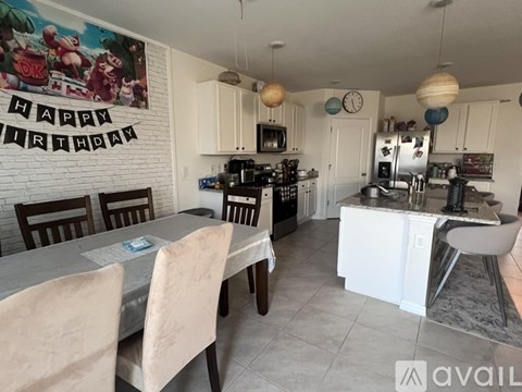 A kitchen with a dining table and chairs.