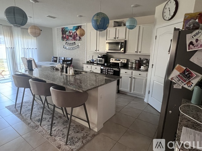 A kitchen with a granite countertop and white cabinets.