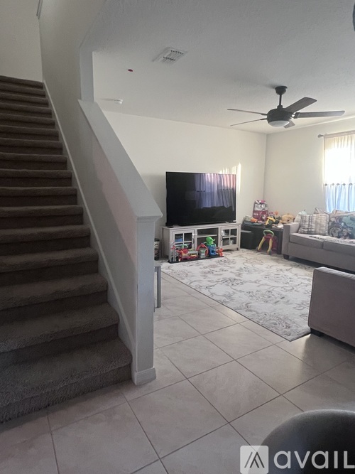 A living room with a staircase leading to the upper floor.