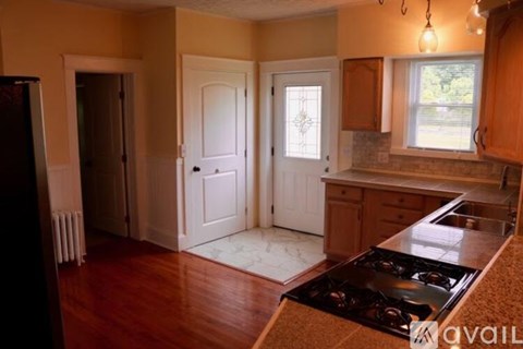 A kitchen with a stove top oven and a window.