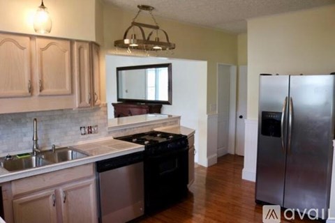 A kitchen with wooden cabinets and a black stove top oven.