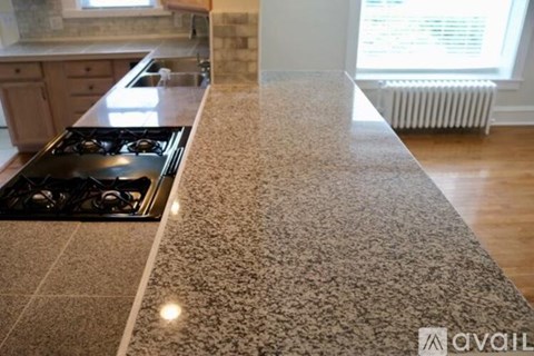 A kitchen countertop with a granite countertop and a stove top oven.