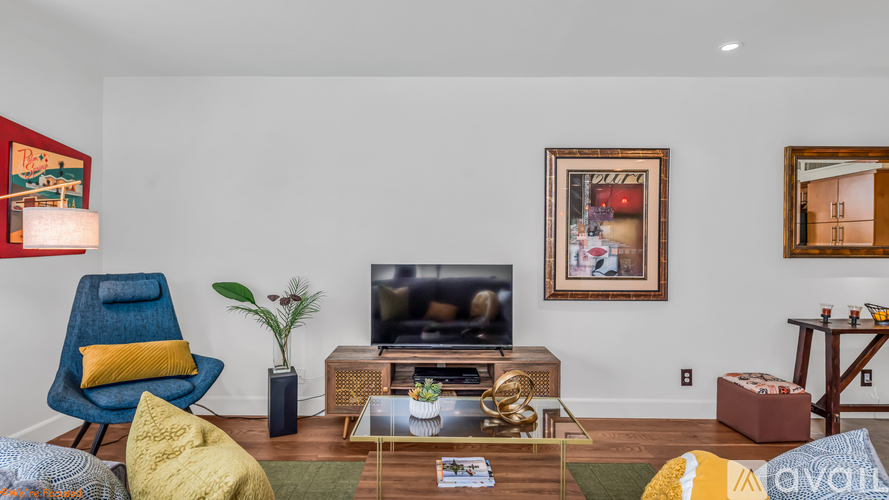 A living room with a blue chair and a yellow pillow.