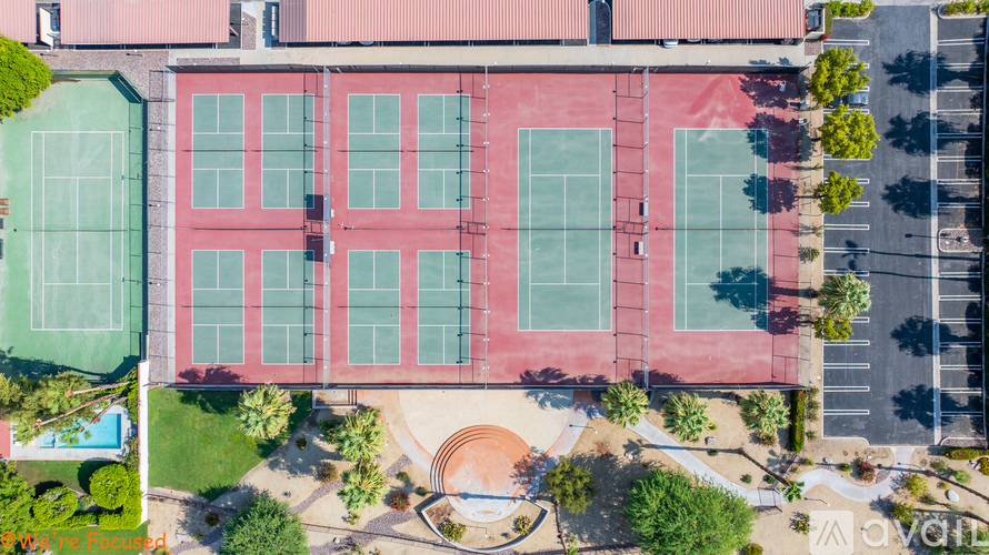 A red building with a tennis court in front of it.
