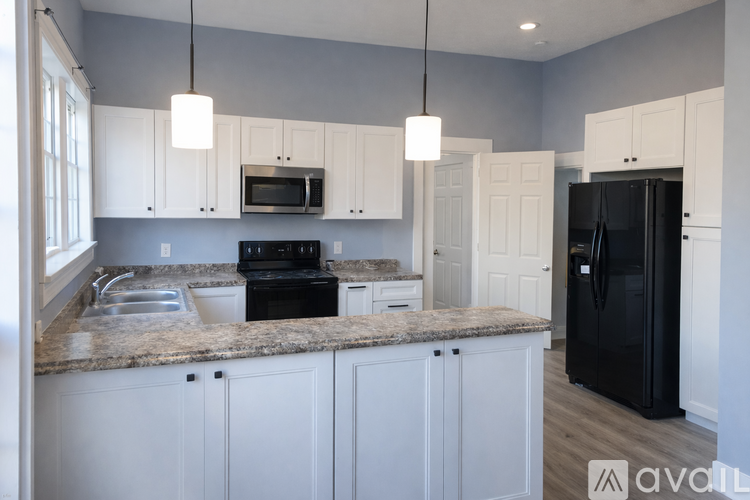 A kitchen with a white fridge and a fan on the ceiling.