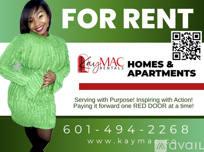 A woman in a green dress is standing in front of a Paymac Homes & Apartments advertisement.
