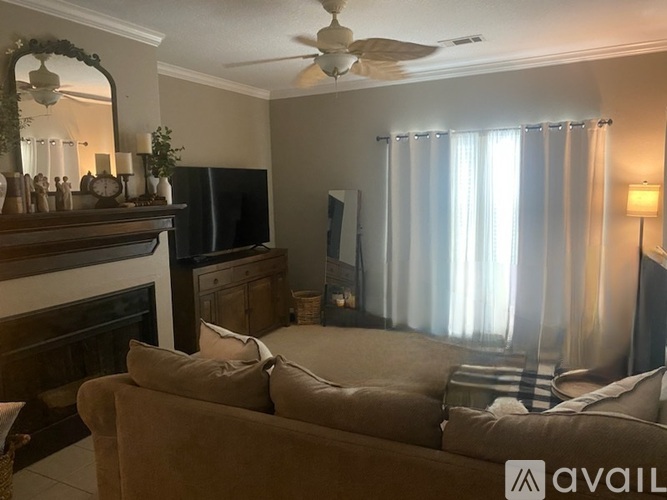 A living room with a couch, a fireplace, and a television.
