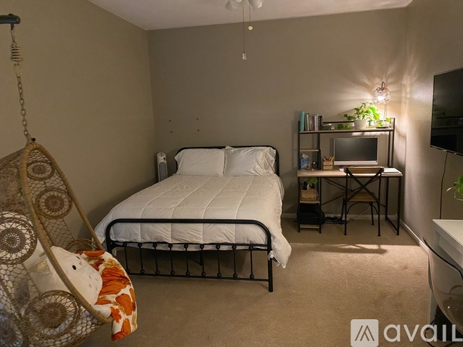 A bedroom with a bed, desk, and chair.