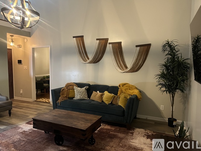 A living room with a grey couch and a wooden coffee table.