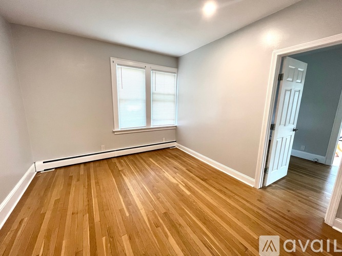 A room with wooden flooring and a window.