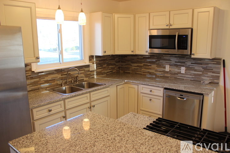 A kitchen with granite countertops and stainless steel appliances.