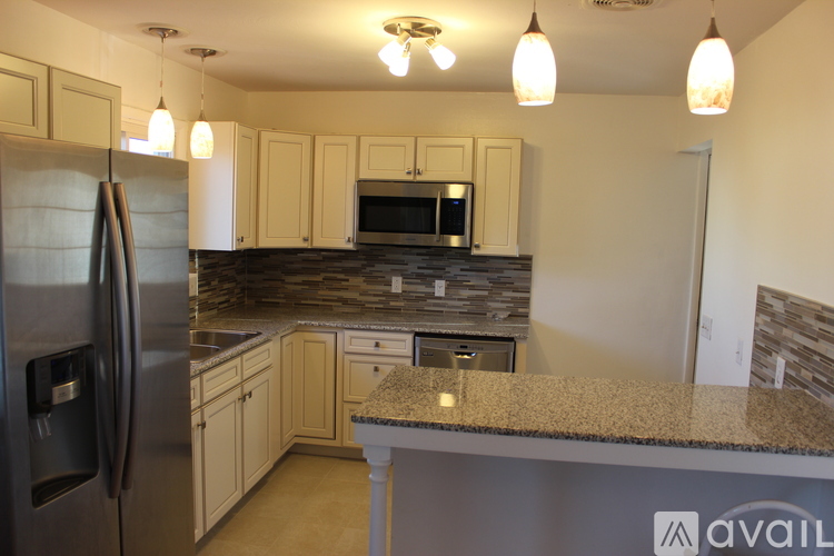 A kitchen with a granite countertop and stainless steel appliances.