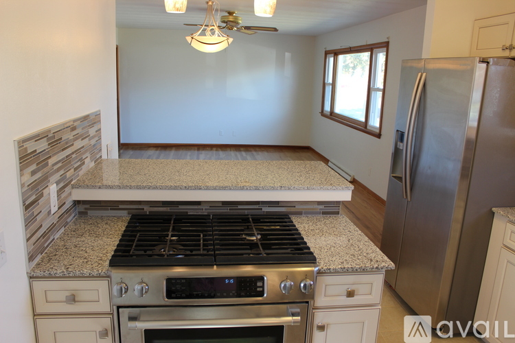 A kitchen with a stove top oven and a refrigerator.